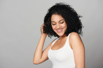 Happy playful smiling mixed race girl on grey background