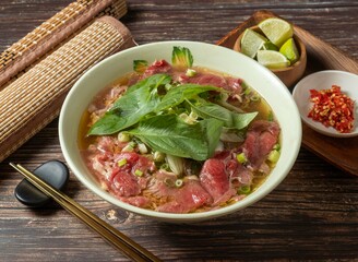 Signature Raw Beef Pho with lime served in bowl isolated on table top view of taiwan food