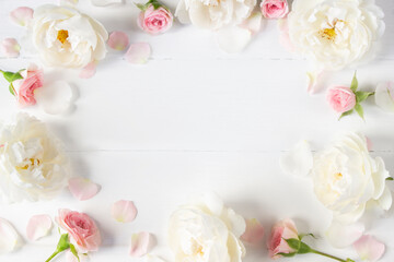 Obraz na płótnie Canvas Flowers template made of pink and white rose flowers. Floral frame. White wooden background. Wedding, Mother's Day, 8 March, Women's day. Flat lay, top view, space for text