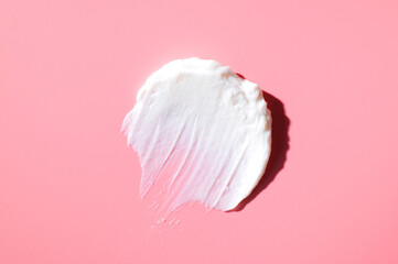 Cosmetics texture. Smear of white face or body cream, lotion, mousse, soap, shower gel on pink...