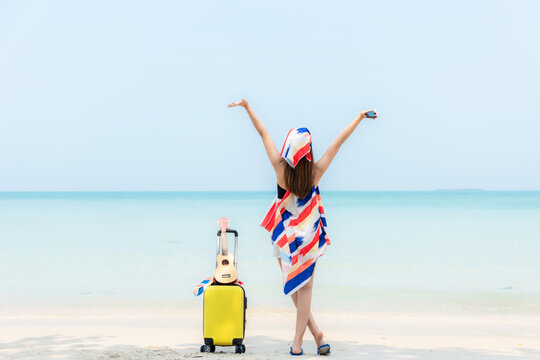 Summer vacations. Lifestyle  woman relax and chill on beach background.  Asia happy young people with bag travel suitcase luggage fashion dress raise arm wave sea, summer trips   tropical beach