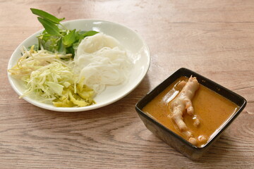 rice noodles with spicy chicken curry sauce and fresh vegetable on plate