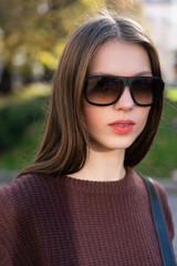 Close up shot of stylish young woman in sunglasses at the street. Beautiful female model