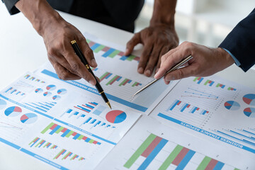 Asian businessman brainstorming to analyze financial reporting situation, investment, income, tax and accounting from data graph. Income, business results, real estate projects at the desk.