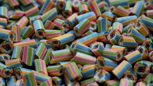 A lot of small multi-colored handmade caramel candies in a modern pastry shop. Lollipops or candies with an ice cream pattern inside at a street food festival.