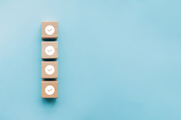 Checklist concept, Check mark on wooden blocks, blue background with copy space - obrazy, fototapety, plakaty