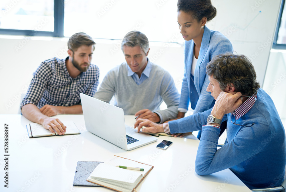 Poster Technology makes brainstorming more efficient. A group of business colleagues discussing work on a laptop during a boardroom meeting.
