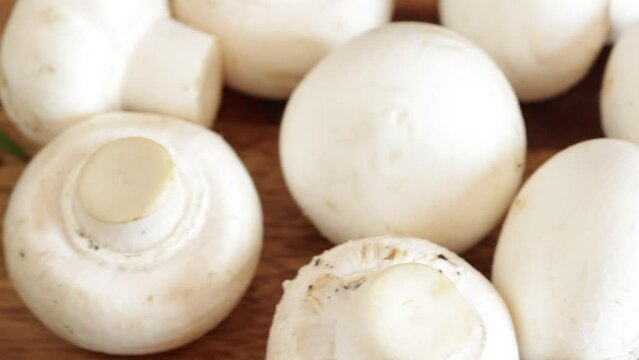 champignons de paris frais, en gros plan, sur une table en bois