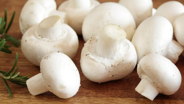 champignons de paris frais, en gros plan, sur une table en bois