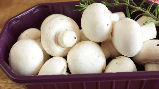 barquette de champignons de paris frais, en gros plan, sur une table