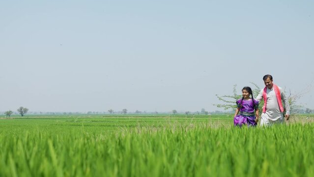 Happy playful kid with villager farming father at farmland - concept of freedom, rural India and caring father