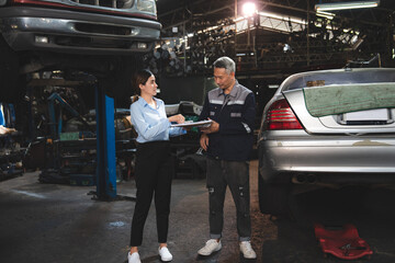 Young female car service manager giving quotation on a clipboard to senior male client and customer...
