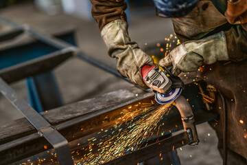 Fototapeta na wymiar Factory worker grinding a metal,close up