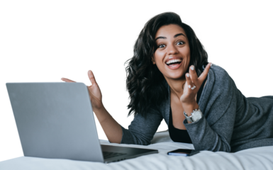 Excited African American young woman in grey cardigan toothy smiles laying on couch with laptop surprised opened mouth in disbelief amazed by new gadget. Student against transparent background. Winner