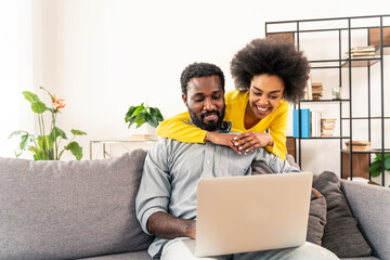Afro couple using computer laptop at home