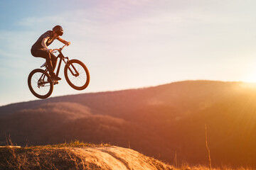 Naklejka na ściany i meble Young man on a mountain bike performing a dirt jump