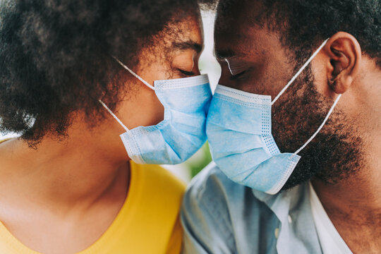Afro american couple at home wearing face masks during coronavirus pandemic