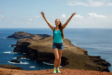 Happy tourist girl with raised hands. Visit Madeira island, Portugal.