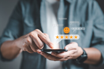 Male customer using smartphone making review satisfaction survey on excellent five star rating and...