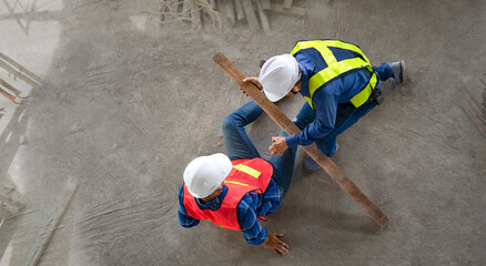 accident in site work,a piece of wood fell from height hit on a worker's legs while working at a...