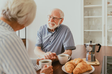 Elderly couple having breakfast at home, old married people in love spending time together 