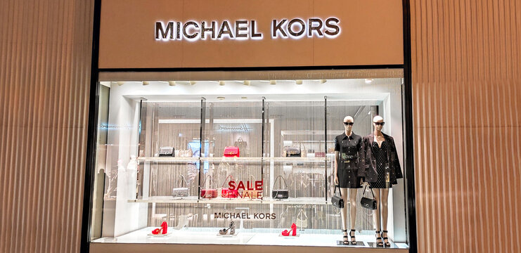 Austria, Vienna - January 7, 2023: Michael Kors - clothing and accessories store. Fashion boutique of famous American designer. Mannequins, bags and shoes in shop window