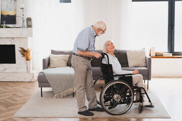 Senior couple, husband takes care of invalid wife on wheel chair - obrazy, fototapety, plakaty