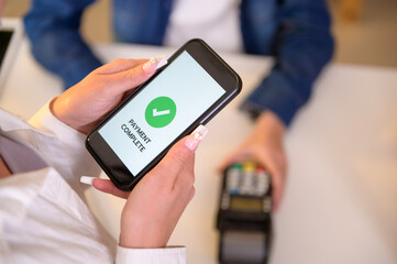 woman customer using QR code payment via smartphone for paying at shop