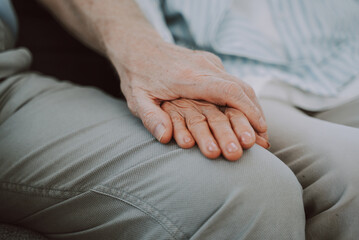 Elderly couple in love hugging on the sofa at home, romantic moments of real senior couple