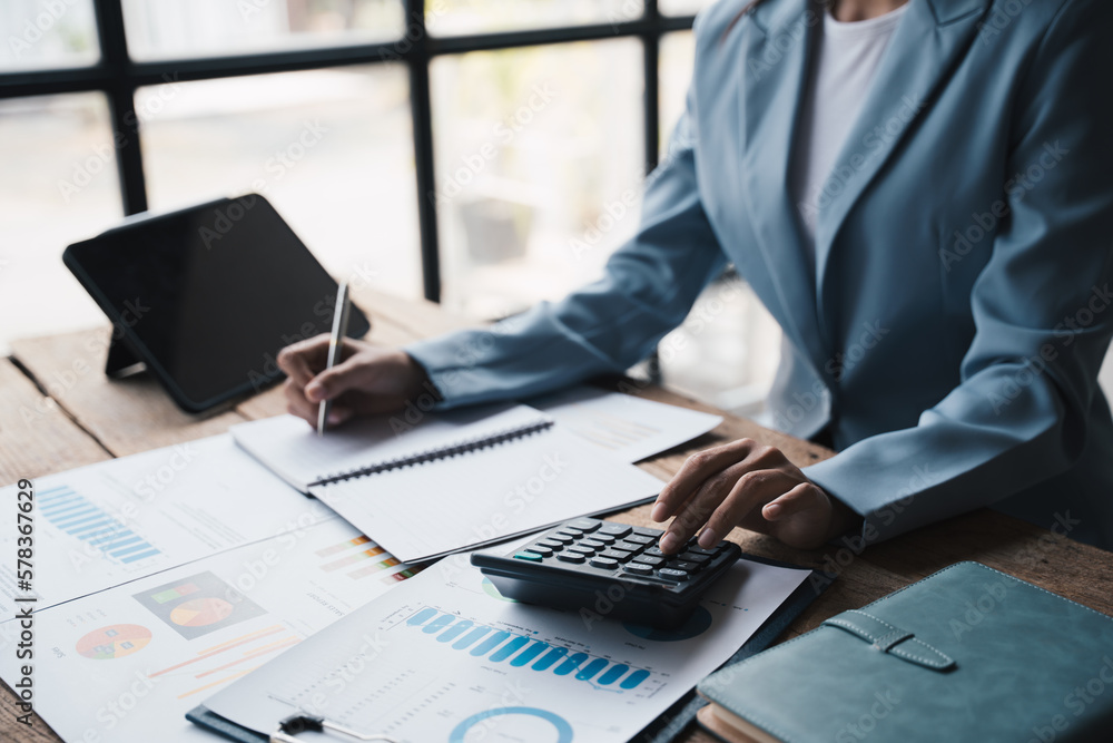 Poster close up view of young asian businesswoman using calculator while analyzing the project budget in of
