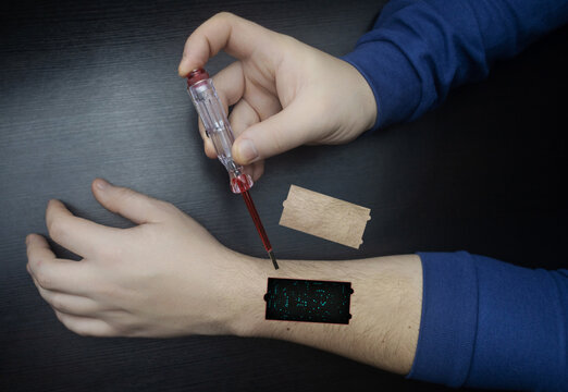 Robot arm concept. Man shows biomechanical prosthetic hand. Guy repairs his hand with tool. Bioengineering, transhumanism, biohacking, human cyborg. Fusion of electronics, mechanics and the human body