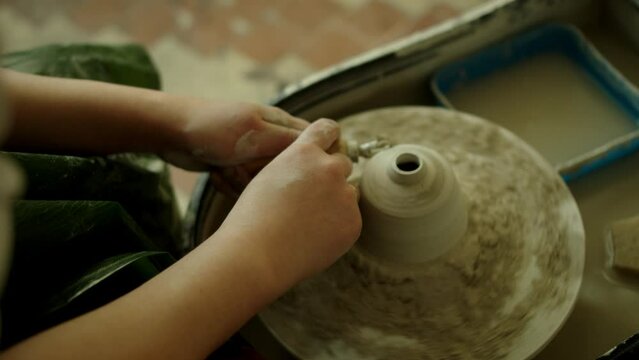 Girl works in her atmospheric craft workshop pottery studio