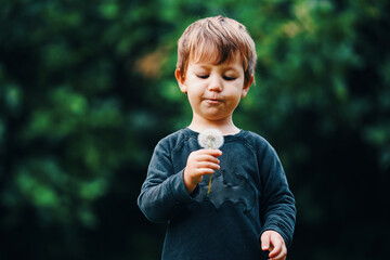 Niño soplando una flor de diente de leon © Marc Elias