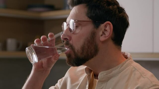 Close up Caucasian man homeowner at kitchen at home drinking glass of water thirty male guy enjoying still pure drink refreshment drink aqua delivery service healthcare balance healthy life habit