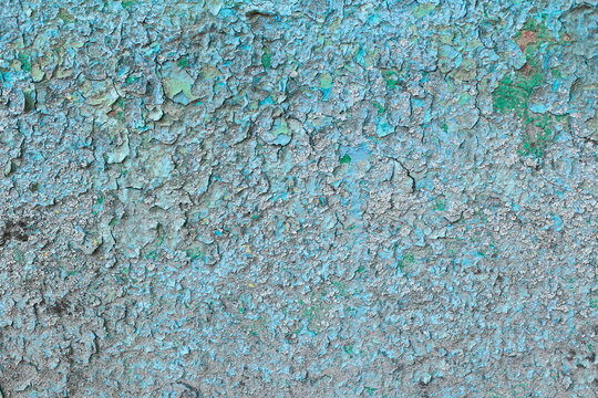 Old rough concrete covered with blue peeling paint.