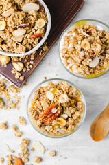 Granola and Yogurt Parfaits, Healthy Breakfast or Snack, Muesli with Nut Mix and Honey on Bright Concrete Background