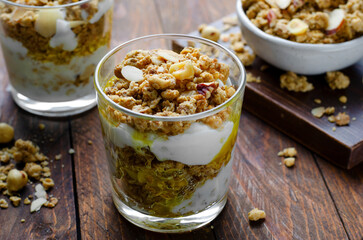 Fototapeta na wymiar Granola and Yogurt Parfaits, Healthy Breakfast or Snack, Muesli with Nut Mix and Honey on Wooden Background