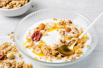 Granola with Nut Mix and Yogurt in a Boal, Healthy Breakfast, Muesli with Nuts and Honey on Bright Background
