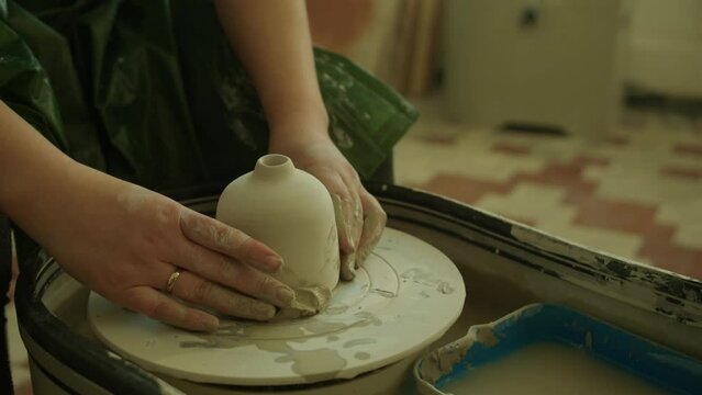 Girl teaching woman in her atmospheric craft workshop pottery studio