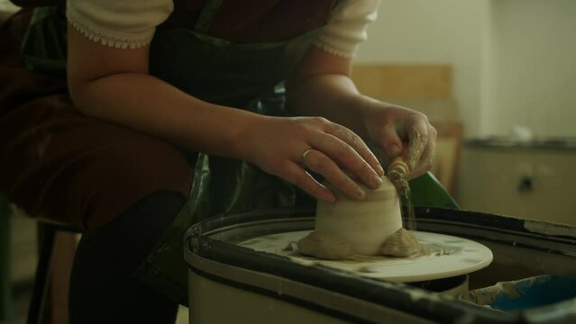 Girl teaching woman in her atmospheric craft workshop pottery studio