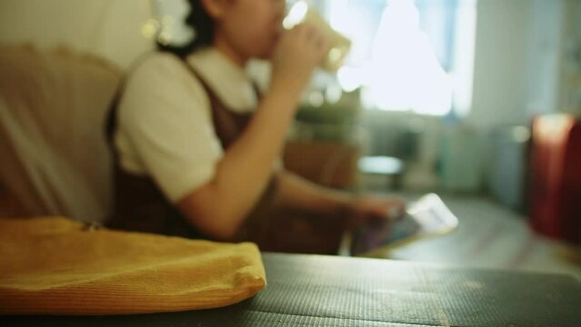 Girl resting in her workshop pottery studio and drink coffee