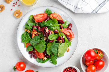 Red Bean Salad On Bright Background, Fresh Salad with Spinach, Cherry Tomatoes, Walnuts, Beans and Mustard Dressing