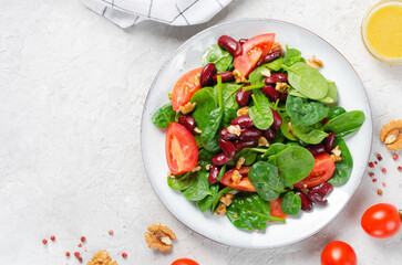 Red Bean Salad On Bright Background, Fresh Salad with Spinach, Cherry Tomatoes, Walnuts, Beans and Mustard Dressing