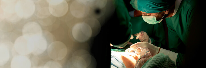 Web banner Team doctors in operating room dressed green uniform saving live critically patient...