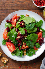 Red Bean Salad On Wooden Background, Fresh Salad with Spinach, Cherry Tomatoes, Walnuts, Beans and Mustard Dressing