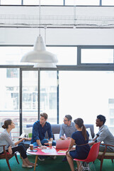 The minds of design. a group of office workers talking together in a meeting room.