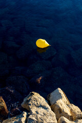 Fototapeta na wymiar yellow bubble in the blue sea near a rock 