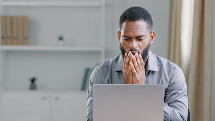 Depressed african businessman frustrated after reading bad news upset man having problem, feels desperate by business failure sitting at office desk. Student got email with failed test exam results