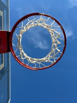 Isolated basketball hoop and net against a blue sky