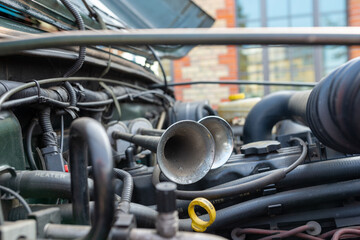 Detail view of the double horns of a classic SUV car inside the engine bay